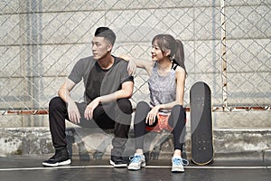 Young asian couple resting and relaxing after outdoor exercise