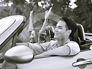 Young asian couple riding in a convertible car