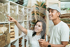 young Asian couple searches for and selects the handicraft products they want to buy