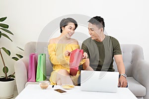 Young Asian couple in sofe websurfing and shpping on internet photo