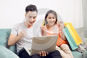 Young asian couple surfing on internet and shopping with laptop.