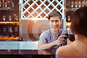 Young asian couple together man and woman clink glasses