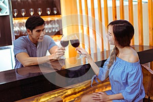 Young asian couple together man and woman clink glasses
