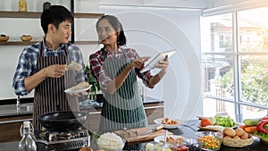 Young Asian couples are happy to cook together, two families are helping each other prepare to cook in the kitchen photo