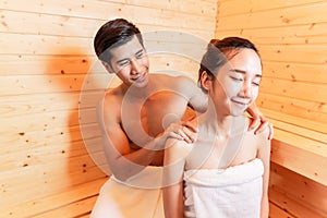 Young Asian couples have romantic relaxing massage in sauna room. Skin care heat treatment and body clean up and refreshing in spa