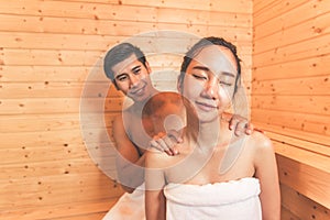 Young Asian couples or lovers have romantic relaxing in sauna room. Skin care heat treatment and body clean up and refreshing in