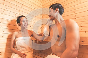 Young Asian couples or lovers have romantic relaxing in sauna room. Skin care heat treatment and body clean up and refreshing in