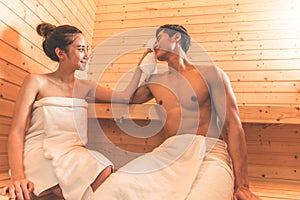 Young Asian couples or lovers have romantic relaxing in sauna room. Skin care heat treatment and body clean up and refreshing in