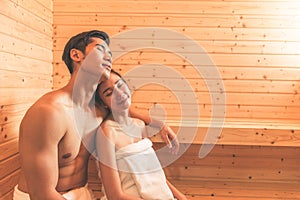 Young Asian couples or lovers have romantic relaxing in sauna room. Skin care heat treatment and body clean up and refreshing in