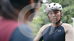 young asian cyclists discussing equipment at roadside