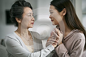 Young asian daughter comforting elderly mother