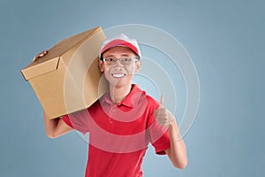 Young asian delivery man carrying package and showing thumb up