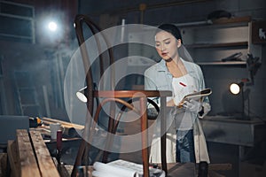 Young Asian designer furniture woman Carpenter uses a tape measure to measure chair