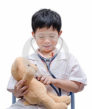 Young Asian doctor boy playing and curing bear toy