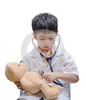 Young Asian doctor boy playing and curing bear toy