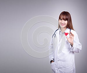 Young Asian doctor stand holding a red heart in her hand