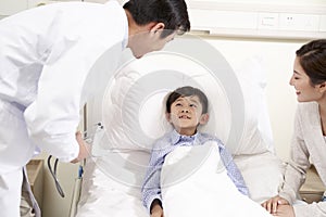 Young asian doctor talking to child patient and mother