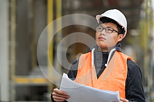Young Asian engineer at work on construction site