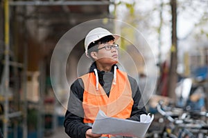 Young Asian engineer at work on construction site