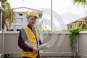 Young Asian engineer inspects architecture, construction project concept, young professional engineer in helmet