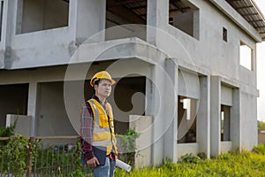 Young Asian engineer inspects architecture, construction project concept, young professional engineer in helmet