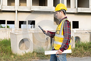 Young Asian engineer inspects architecture, construction project concept, young professional engineer in helmet