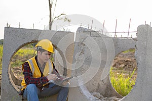 Young Asian engineer inspects architecture, construction project concept, young professional engineer in helmet