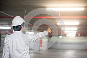 Young Asian engineer man pointing at construction site