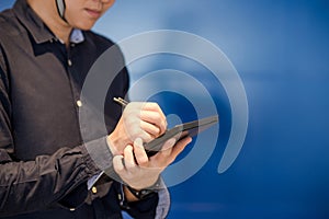 Young Asian engineer man writing on tablet