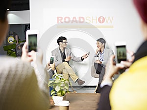 Young asian entrepreneur being interviewed during roadshow