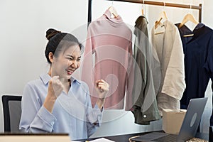 Young asian entrepreneurs are excited about hitting today\'s clothing sales target