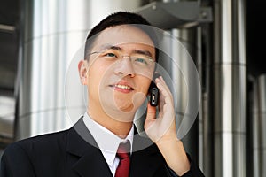 Young asian executive talking on handphone