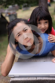 Young Asian family with laptop outdoors