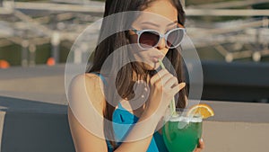 Young asian fashion woman drinking cocktail in a beach bar.