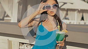 Young asian fashion woman drinking cocktail in a beach bar.