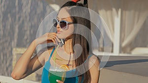 Young asian fashion woman drinking cocktail in a beach bar.