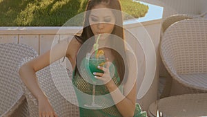 Young asian fashion woman drinking cocktail in a beach bar.