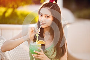 Young asian fashion woman drinking cocktail in a beach bar.