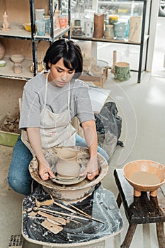 Young asian female ceramicist in apron photo