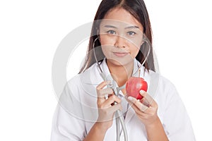 Young Asian female doctor listening to an apple with a stethoscope