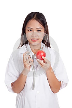 Young Asian female doctor listening to an apple with a stethoscope
