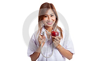 Young Asian female doctor listening to an apple with a stethoscope