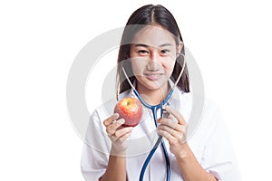 Young Asian female doctor listening to an apple with a stethoscope.