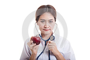 Young Asian female doctor listening to an apple with a stethoscope.