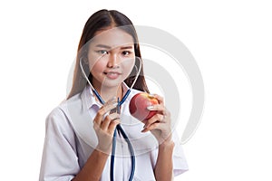 Young Asian female doctor listening to an apple with a stethoscope.