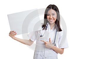 Young Asian female doctor point to a blank sign.