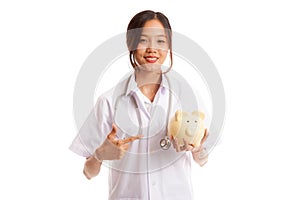 Young Asian female doctor point to a pig bank coin