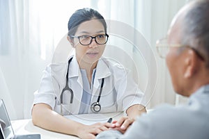 Female doctor reassuring senior male patient.