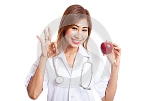 Young Asian female doctor show OK with apple