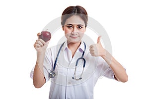 Young Asian female doctor thumbs up with apple.